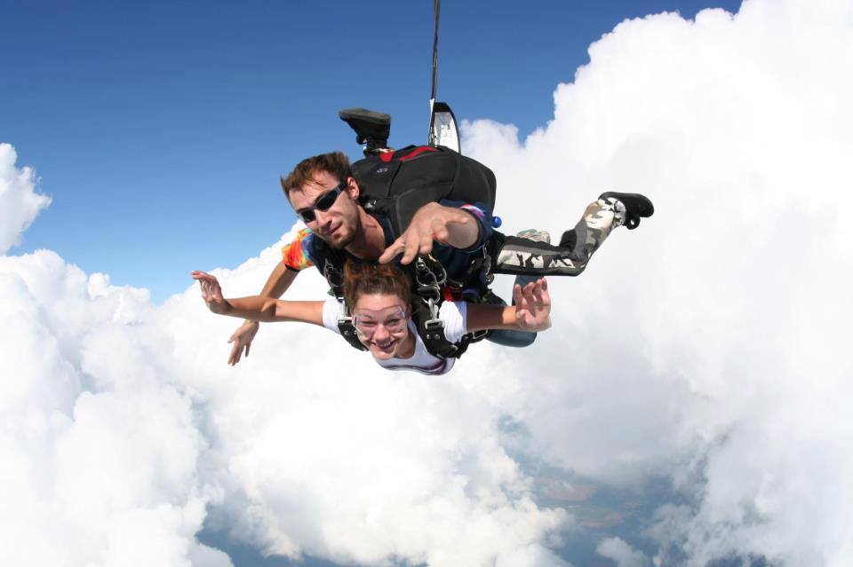 Tandem skydivers looking happy in mid free fall