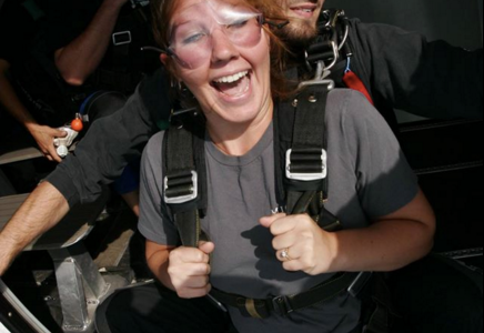 Happy tandem skydiving student about to jump from a plane