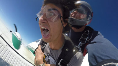 Tandem skydiving student yelling during free fall