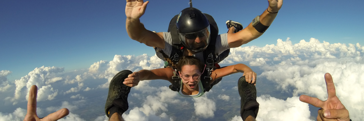 Tandem skydiver holds onto instructors feet