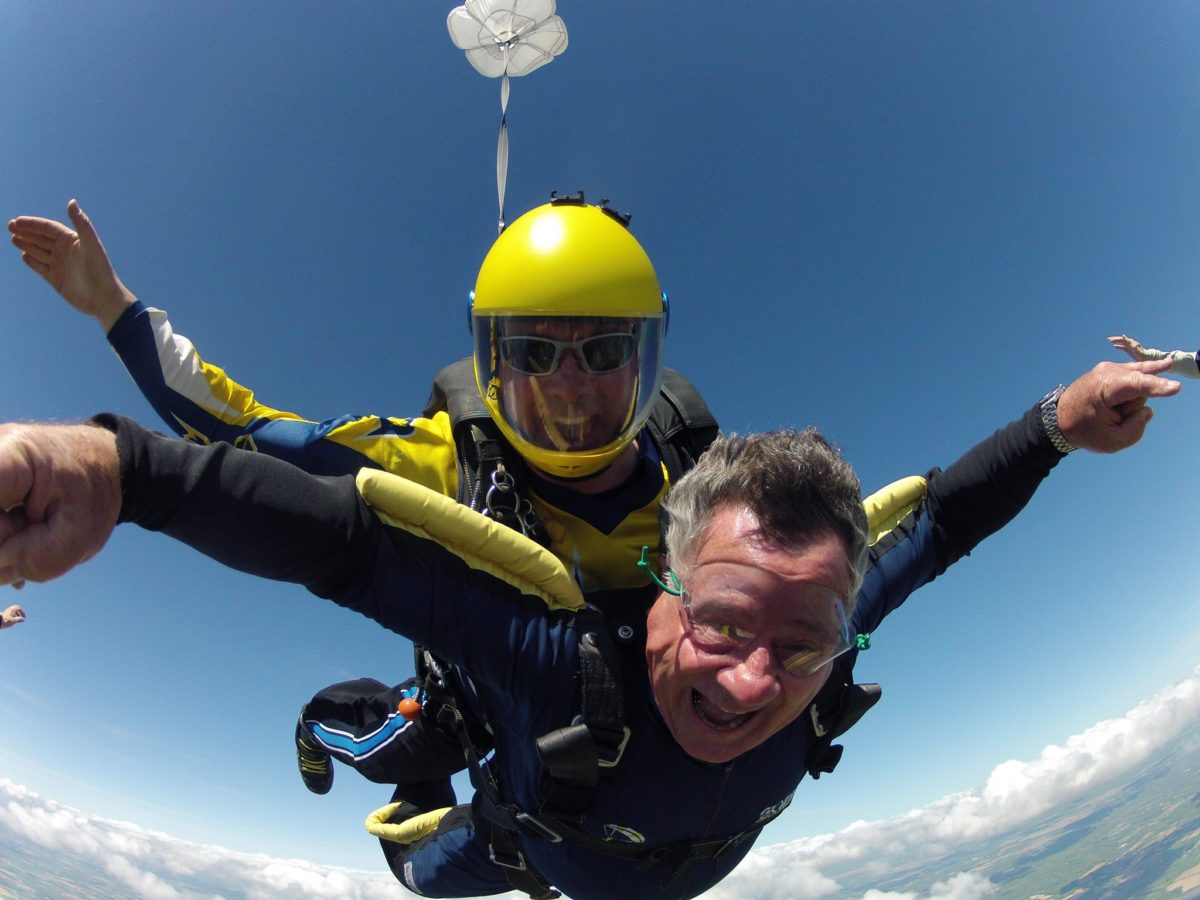 Skydive instructor and tandem student looking stoked during free fall