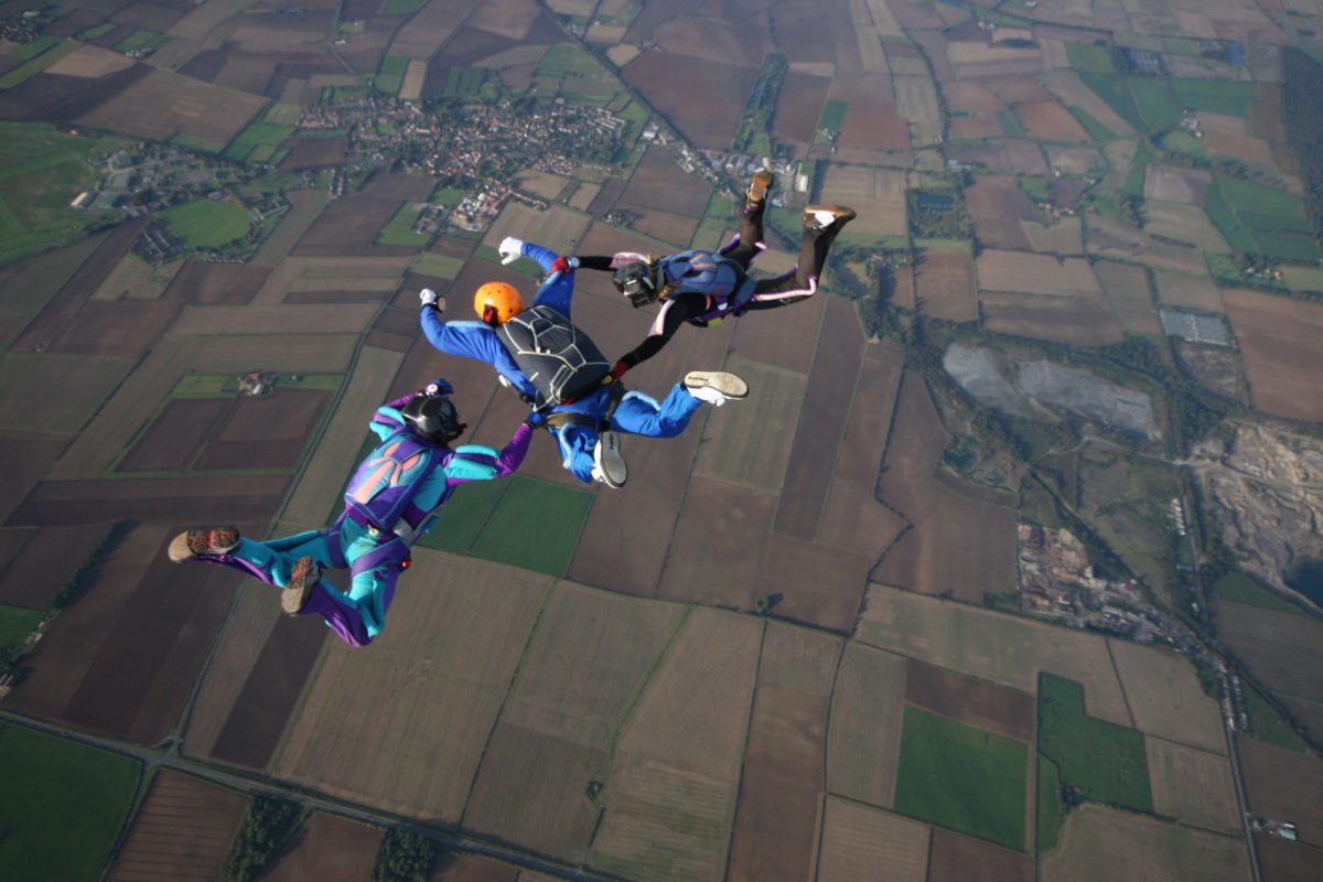 Three skydivers making a formation during free fall