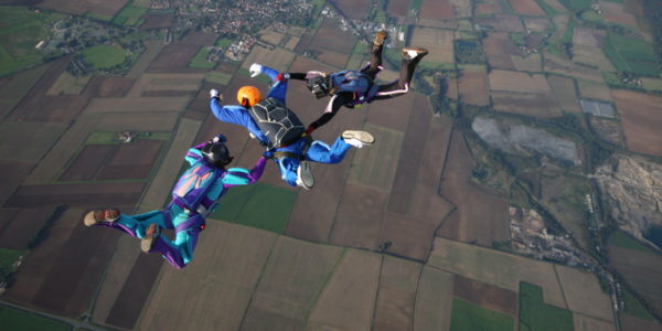 Three skydivers making a formation during free fall