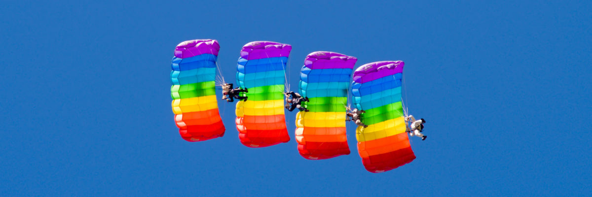 Skydivers forming a line while parachuting