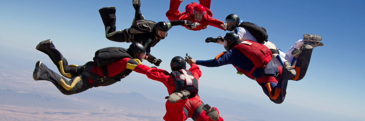 Skydivers holding hands in a circle