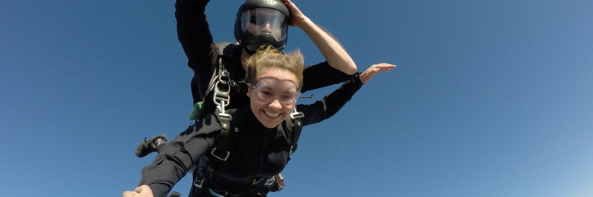 Tandem skydiver smiling at the camera while in free fall