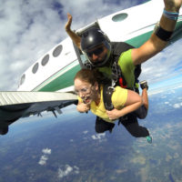 Tandem skydivers jumping out of an airplane on a gorgeous day