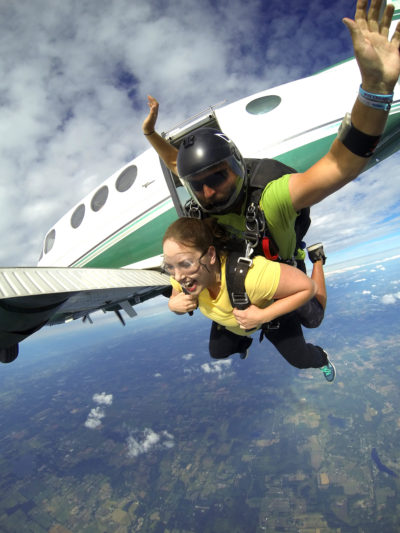 Tandem skydivers jumping out of an airplane