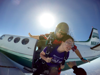 Tandem skydivers jumping out of a plane