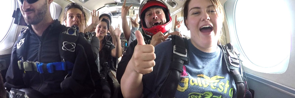 Skydivers giving a thumbs up during the plane ride