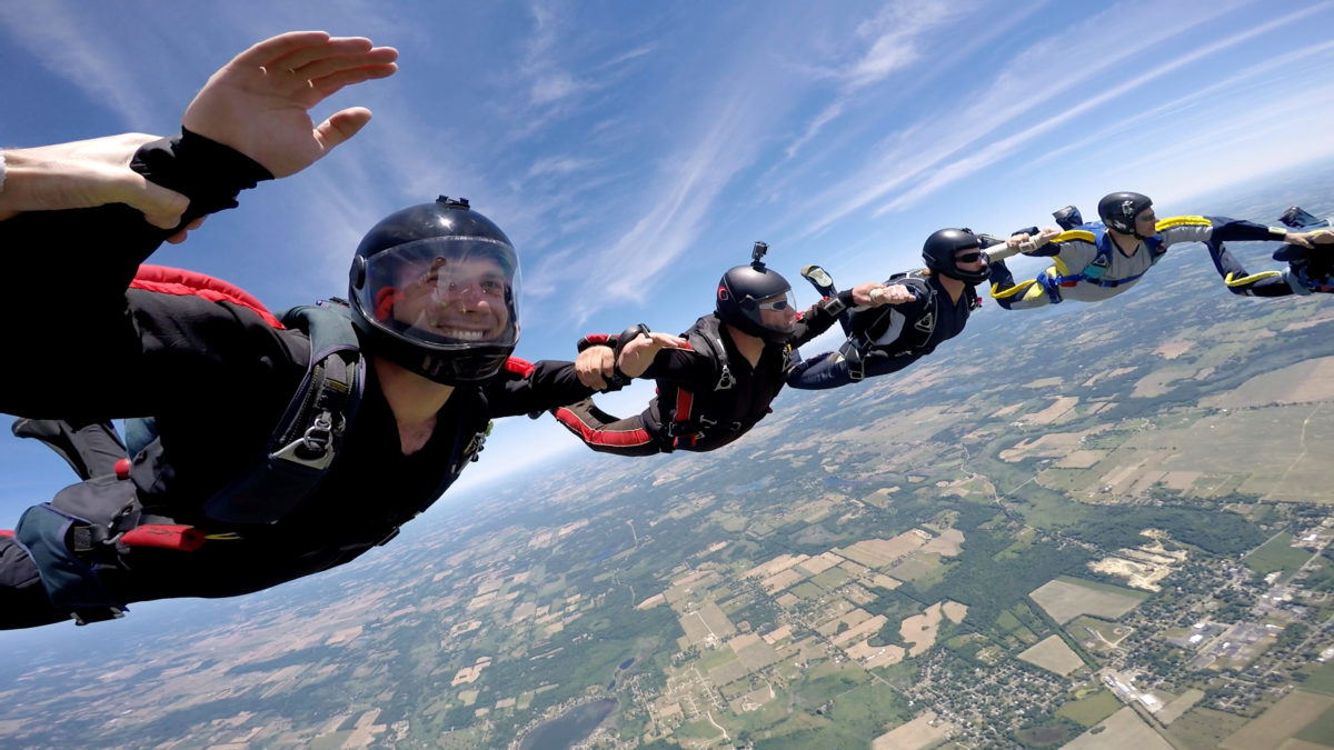 A group of skydivers locking arms to make a formation